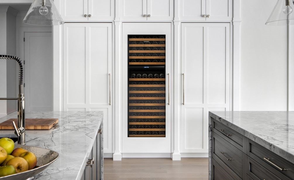 sub zero fridge with see through door wine cooler in upscale home kitchen with white cabinets
